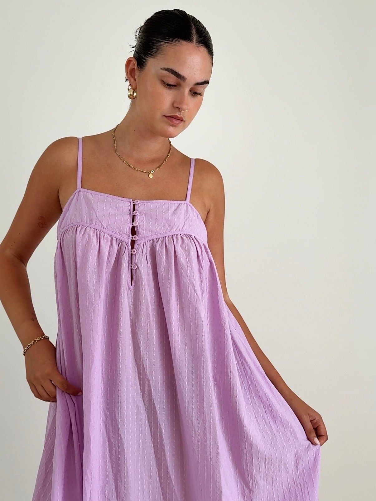 Woman wearing a light purple dress against a plain background