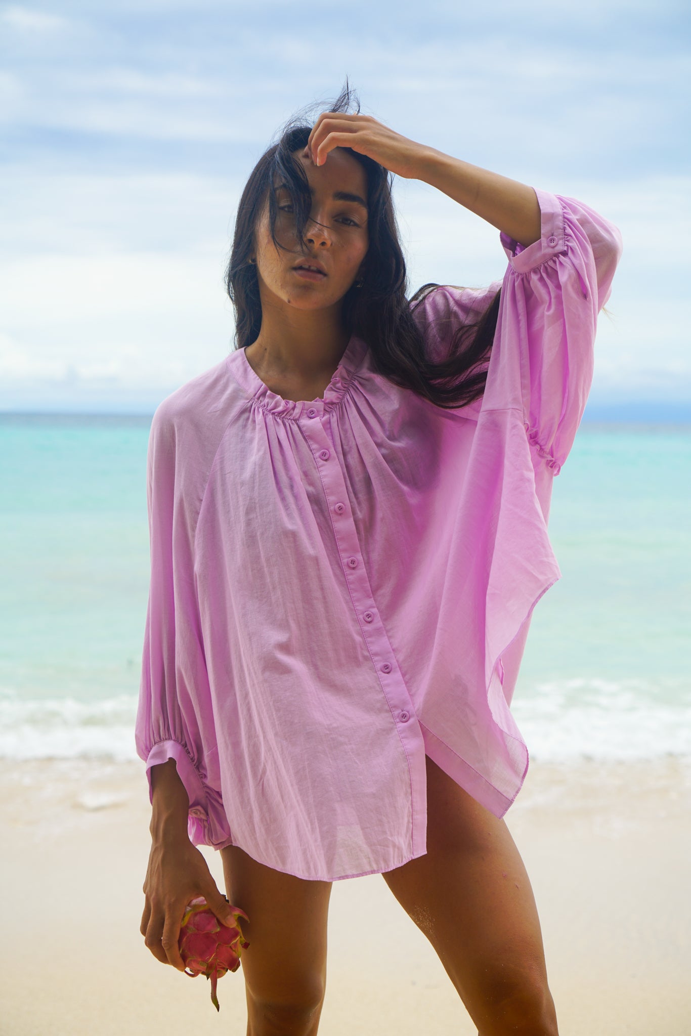 Close up of LILLY PILLY woman wearing a orchid Thalia cotton voile shirt blouse with a blurred background by the ocean